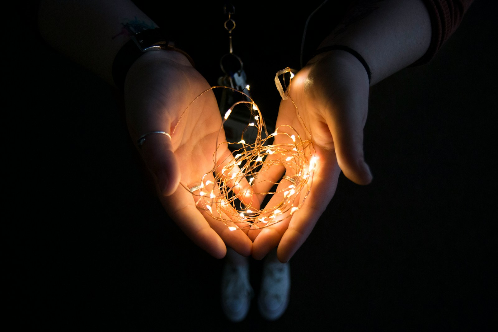 Photo by Chris Moore yellow string light on human hand